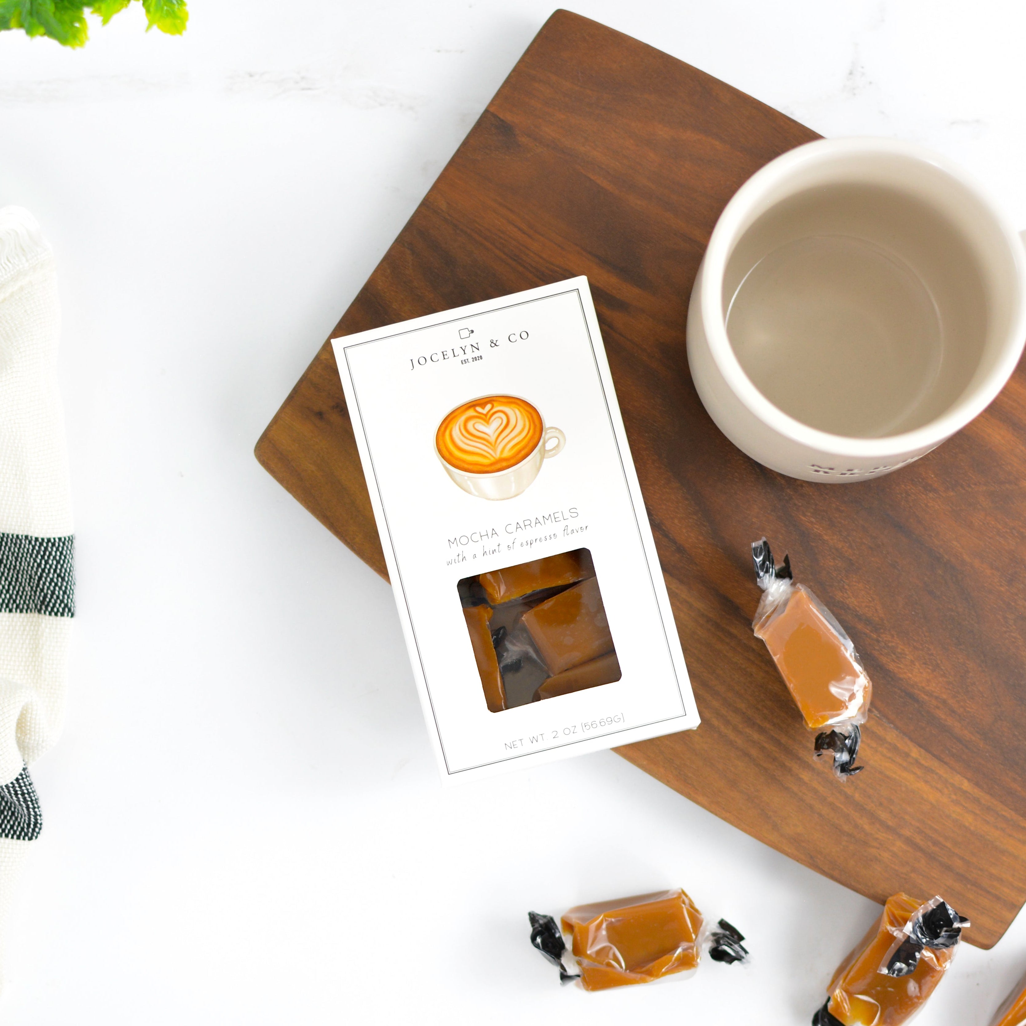 Coffeepods on a wooden tray with a coffee cup and card on a hite background