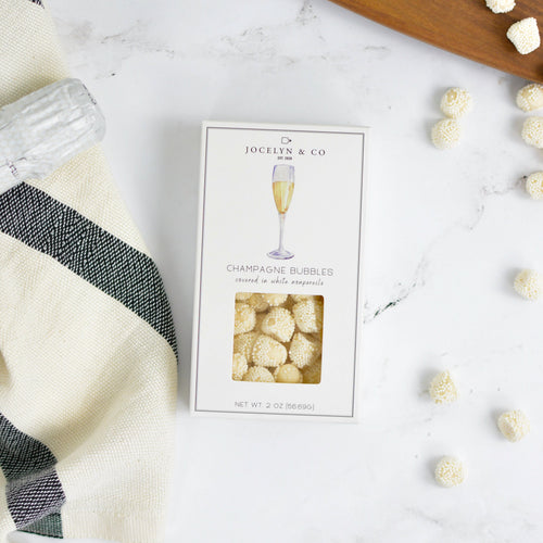 Jocelyn & Co. Champagne Bubbles packaging on a marble surface with decorative items.